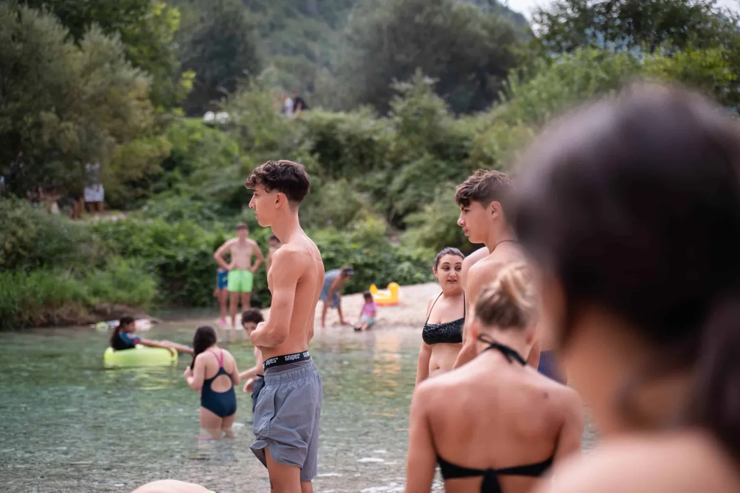 Ragazzi del camp al torrente, tra i boschi di montagna