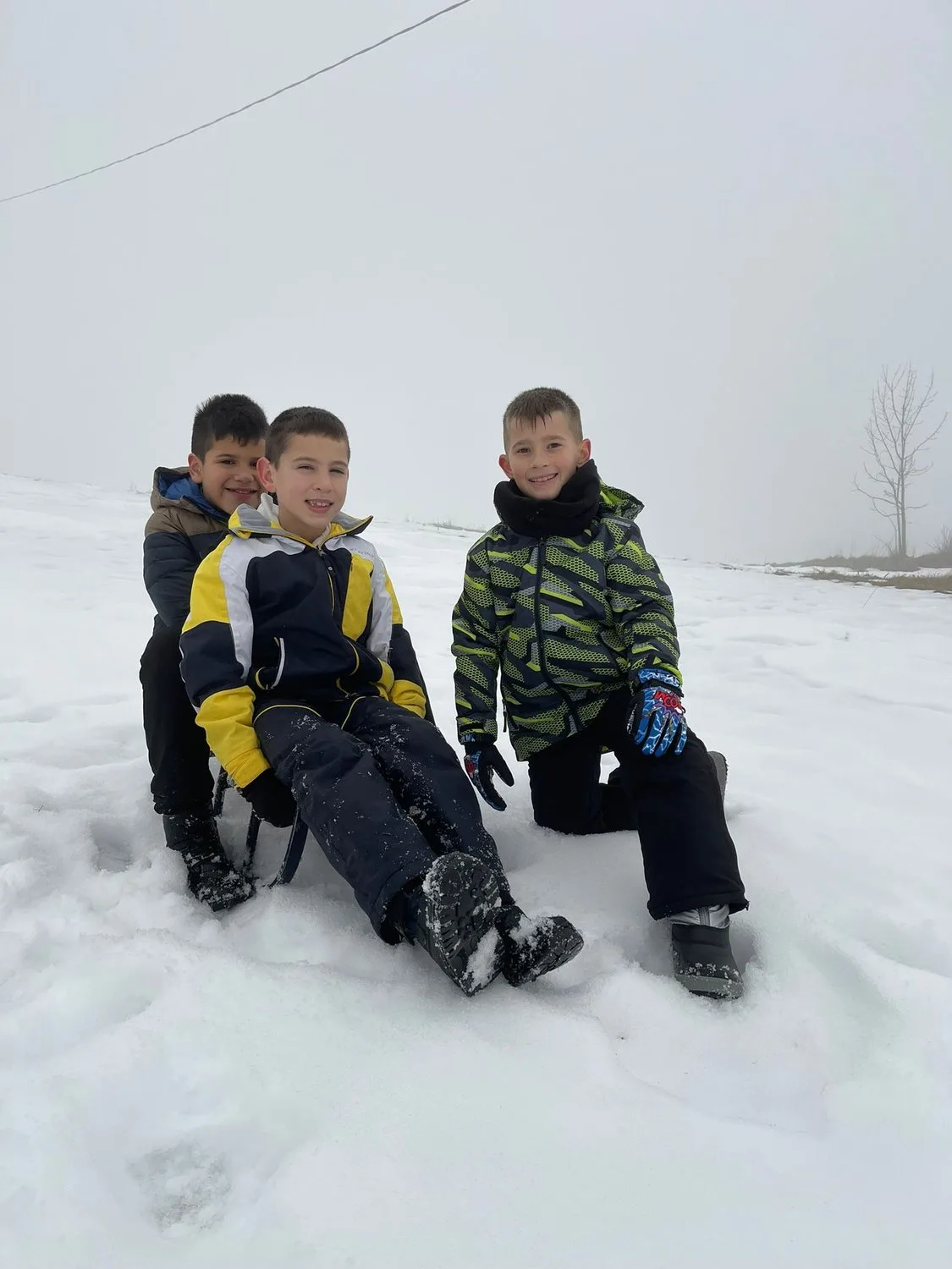Tre bambini del Camp seduti sulla neve