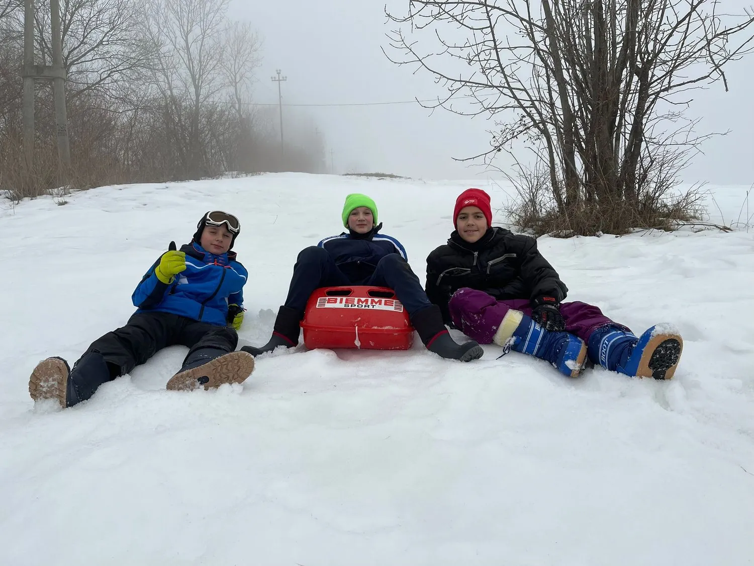 Bambini del Camp che giocano con lo slittino sulla neve